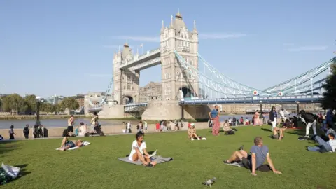 Reuters File image of people sunbathing with Tower Bridge in the distance