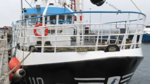 Fishing boat called the Kingfisher tied up in a harbour