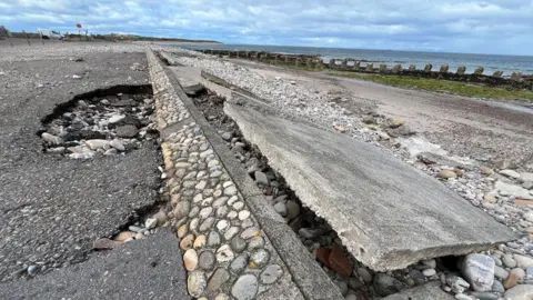 A barrier on the seafront which has been eroded by water