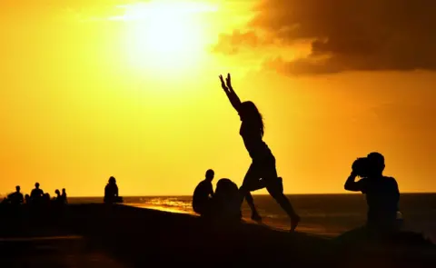 David Silverman/Getty People gather to enjoy the sunset on the Malecon