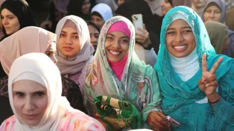 A group of women pose for the camera while attending prayers to mark the end of Ramadan