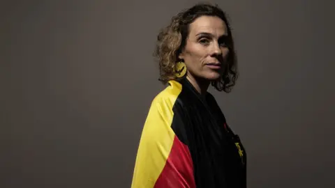 Getty Images Laura Thompson wearing an Aboriginal flag draped around her shoulders