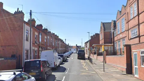 A residential street with two schools on one side of the road