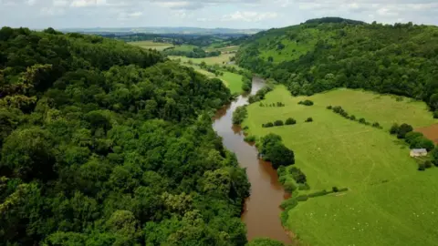 BBC Aerial shot of the River Wye running between hills, forests and green fields