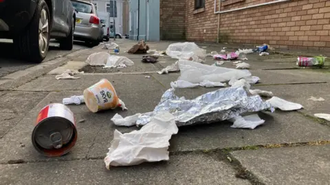 BBC Litter strewn across a Cardiff street, including empty cans, tissues and foil