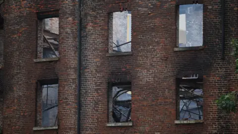 EPA The charred former Hotspur Press building in Manchester city centre after Monday's large fire.