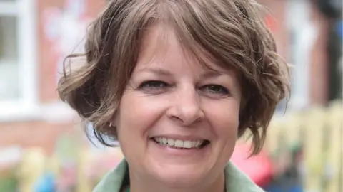 CAROLINE GRATRIX picture of Ruth Perry, a smiling lady with short brown hair