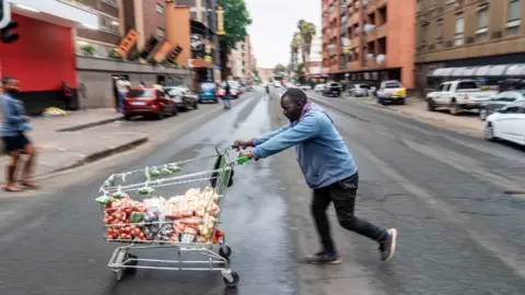 BBC/Shiraaz Mohamed Helder Massingue with his trolley of vegetables in Hillbrow, Johannesburg, South Africa