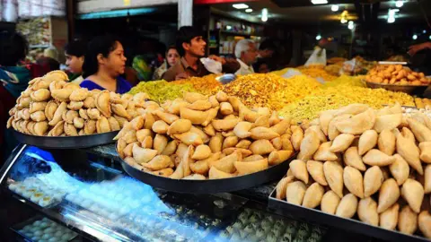 Getty imagens doces e salvamentos indianos tradicionais preparados para o festival que está sendo vendido em uma loja