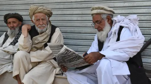 Getty Images Residents of Quetta in Balochistan sit to read the newspaper.