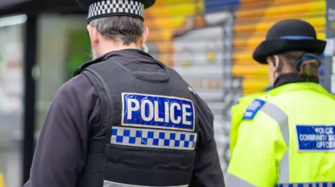 PCC/TVP Two police officers walking away from the camera side by side.