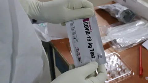 Getty Images Kolkata health worker with swab test kit