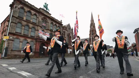 PA Media Members of the Orange Order take part in a Twelfth of July parade in Belfast, part of the traditional Twelfth commemorations