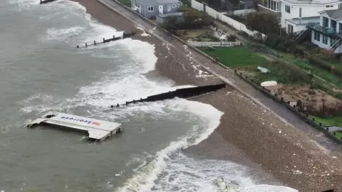 Eddie Mitchell A shipping container floats in the sea. 