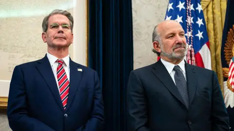 To men stand in suits