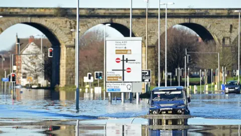 Getty Images A man drives through the flood-waters on Kirkstall Road in central Leeds on December 27