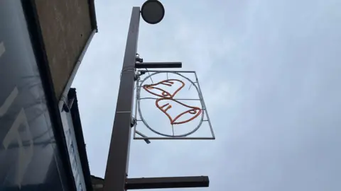 Gareth Lightfoot Christmas lights depicting jingle bells are attached to a light post. The design is not illuminated in this picture.