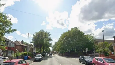 Crescent Road, which has semi-detached houses, trees, lampposts, parked cars and telegraph poles.