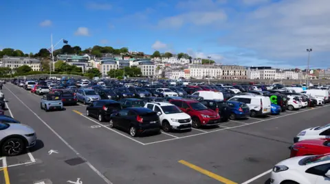 BBC North Beach Car Park, a large car park where there are a number of cars of different colours parked. 