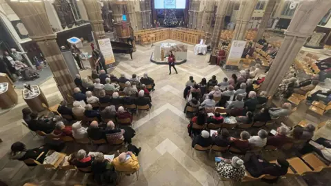 The congregation mid-song viewed from above in the vast open space of Leicester Cathedral