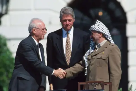 Cynthia Johnson/Liaison Yasir Arafat and Israeli Prime Minister Yitzhak Rabin shake hands on 13 September, 1993 in Washington DC