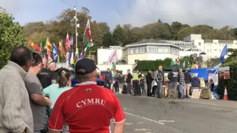 Protesters gather outside the Stradey Park Hotel in Llanelli when plans to use it for temporary housing for asylum seekers was announced.