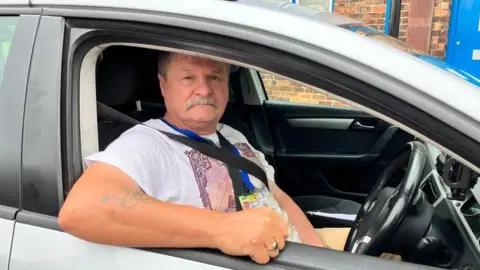 Image of John Lofthouse in his car leaning out window