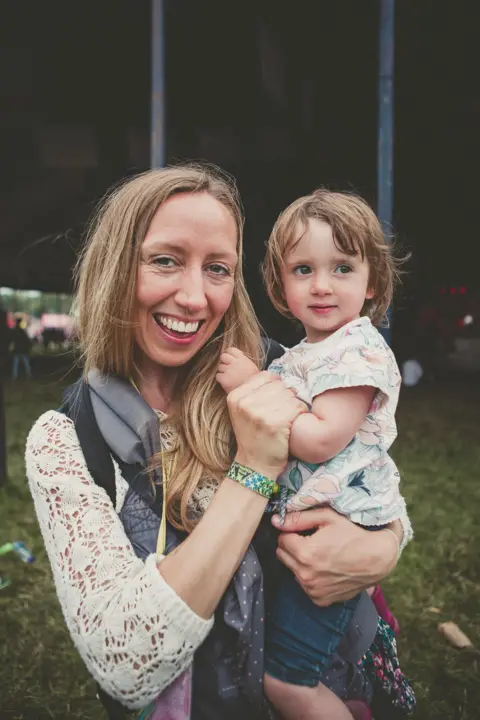 Zoe Hitchen Alt: Woman holding a child