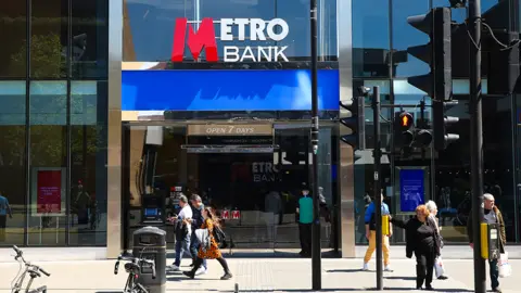 Getty Images People walk outside a Metro Bank branch