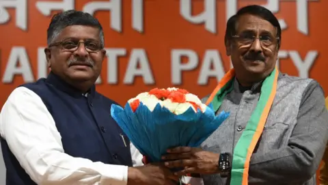 Getty Images Union minister Ravi Shankar Prasad hands a bouquet of flowers to Tom Vadakkan