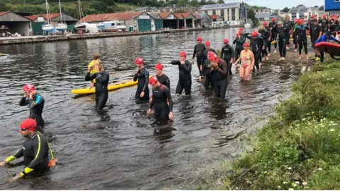 Dart 10K swimmers at Steamer Quay in wet suits and swimming caps