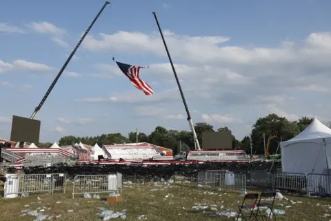 The rally grounds at Butler Farm Show show discarded bottles and debris and an American flag