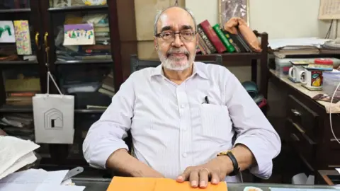 Jehangir Patel, wearing a white shirt, seated in his office in La Parsiana in Mumbai