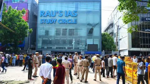  Security personnel stands guard out side Rau's Study Circle in view of incident of last night flooding which claims three students lives at Old Rajinder Nagar, on July 28, 2024 in New Delhi, India. Delhi's IAS coaching center on Saturday became flooded following heavy rainfall and claimed the life of three UPSC aspirants trapped in the basement. The incident occurred after a nearby drain burst open causing a deluge in the basement of the popular coaching centre in Central Delhi. UPSC aspirants held a night-long protest, demanding immediate action from the authorities following the incident at the coaching institute. (Photo by Vipin Kumar/Hindustan Times via Getty Images)