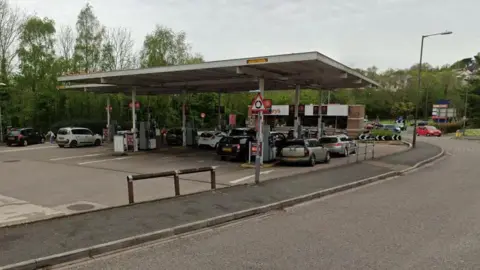 Google Street View image of the petrol station at Sainsbury's on Nicholson Road in Torquay with about 10 vehicles using the pumps.