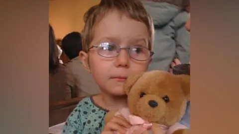 Family handout Olivia Legg at a very young age, clutching a teddy bear.