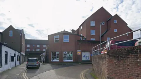 A residential road with a car parked next to a building.