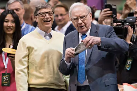 Warren Buffett, Berkshire Hathaway Inc. chairman, right, talks with Bill Gates, billionaire and co-chair of the Bill and Melinda Gates Foundation, as they tour the exhibition floor during the Berkshire Hathaway Inc. annual shareholders meeting in Omaha, Nebraska, U.S., on Saturday, May 2, 2015.