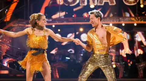 Woman and man in yellow outfits dancing