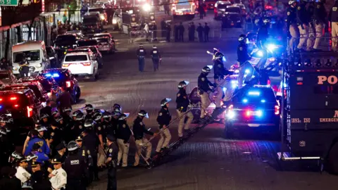 Reuters Police are in a line at Columbia  enter Hamilton Hall from a public street with flashing lights at night
