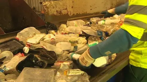 Empics A worker sorts out recycling