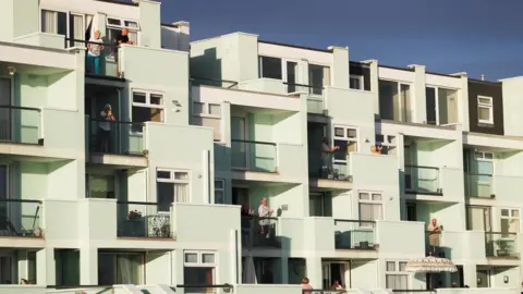 Getty Images People clapping on a balcony