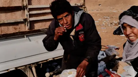 Gabriel Chaim Amer eating from a rubbish dump