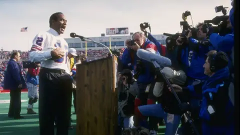 Getty Images O.J. Simpson on the mike during a half-time ceremony of a game between the Buffalo Bills and the Indianapolis Colts at Rich Stadium in Orchard Park, New York, in 1993.