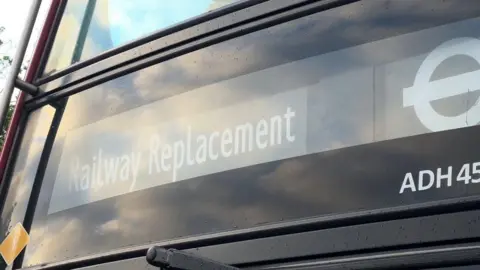 A close up of a bus marked Railways Replacement.