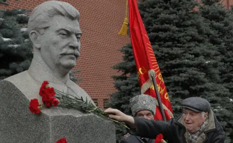 EPA Stalin statue and Communist supporter at Kremlin, Dec 2017