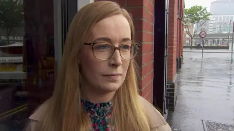 A woman with glasses, she has blonde hair