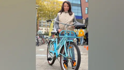 Anna Holligan Sanne with the sky-blue bike she chose at the bike bank