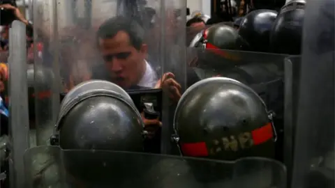 Reuters Mr Guaidó pushes against a riot shield on 7 January 2020