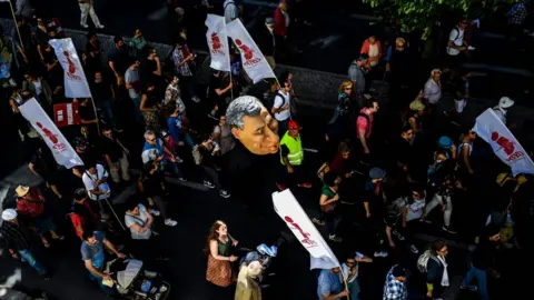 PATRICIA DE MELO MOREIRA Protesters hold a puppet of Portuguese Prime Minister Antonio Costa during a rally in Lisbon